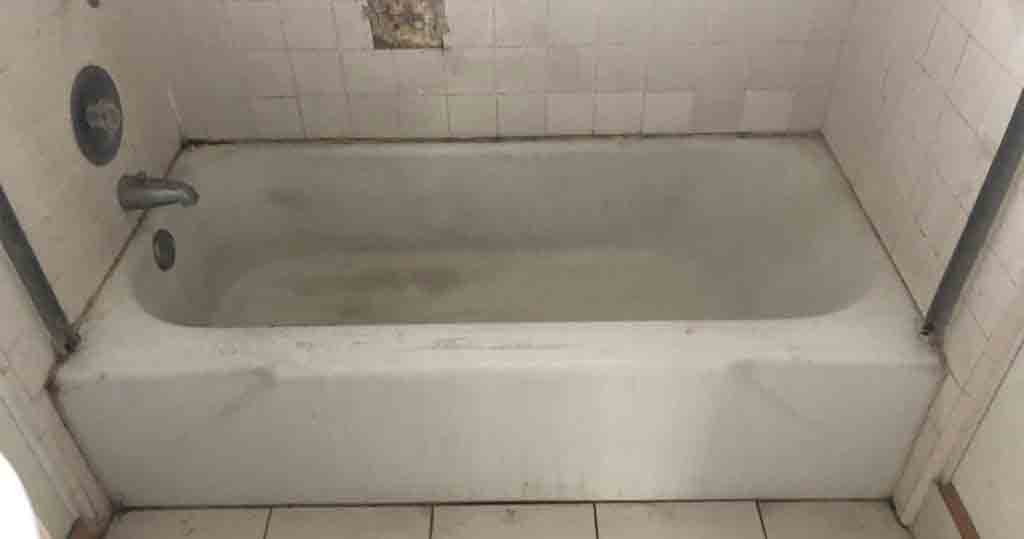 Bathtub before refinishing and tile resurfacing work